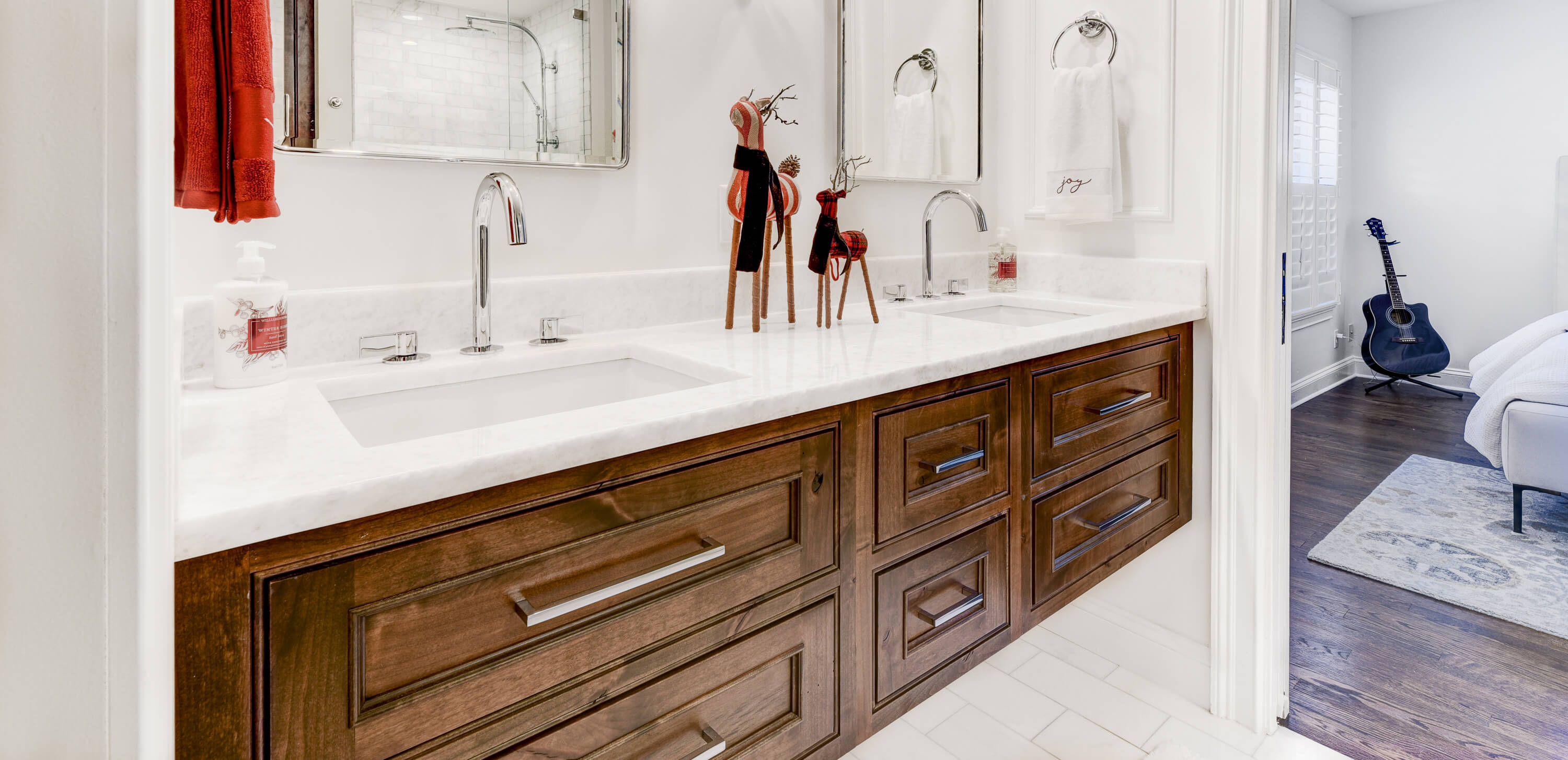 A warm, knotty alder floating bath vanity with inset cabinet doors in a remodeled master bathroom. This bath is decorated with festive red, reindeer holiday decor.