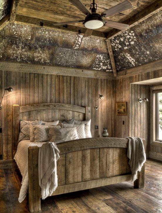 A rustic style bedroom design with a vaulted ceiling.