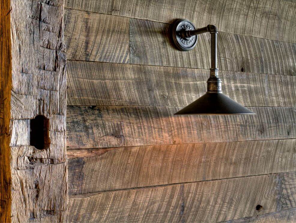 Rugged rustic textured wall with wood planks and an industrial style light fixture.