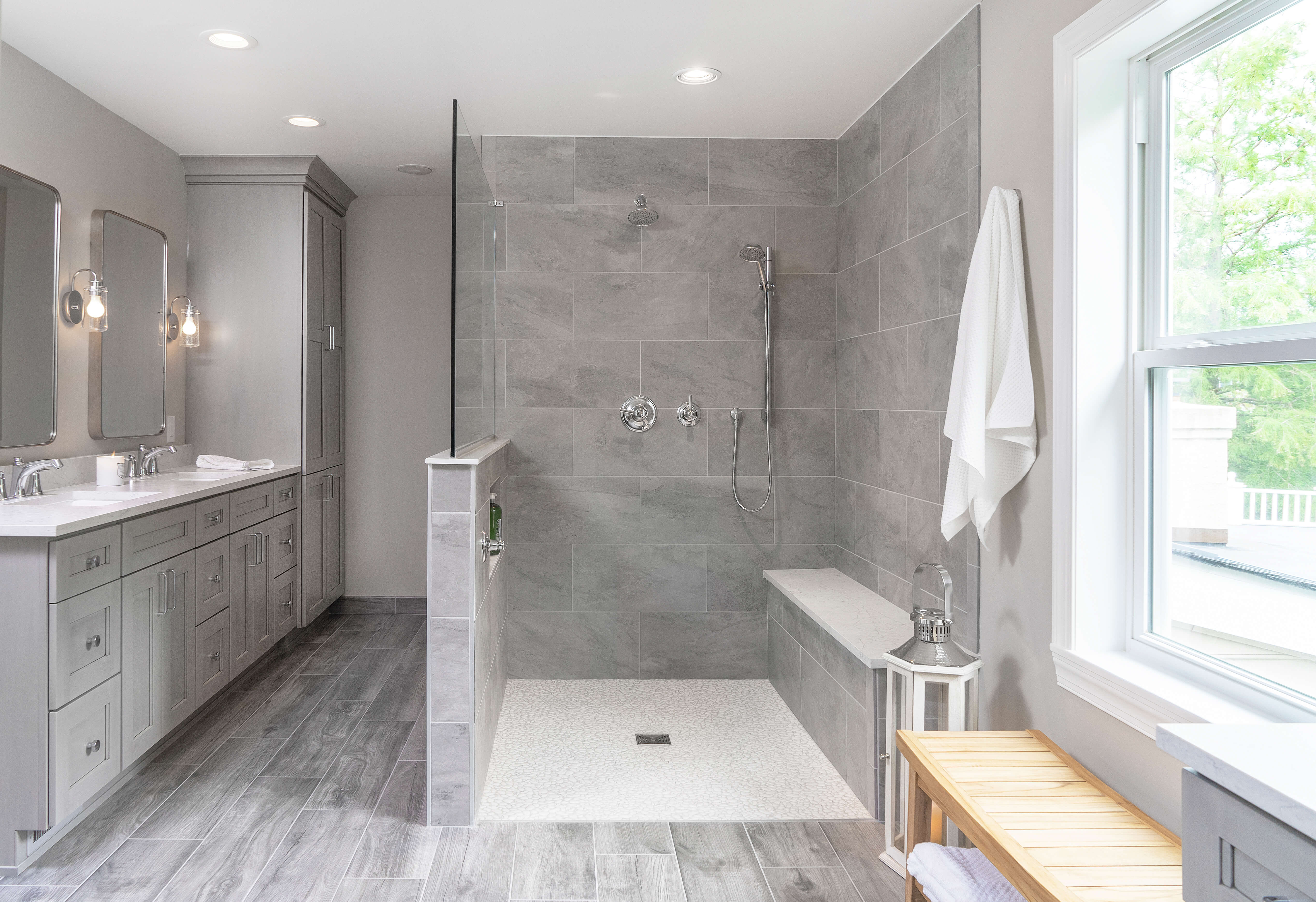 A beautiful master bathroom with a light gray vanity and walk-in shower.