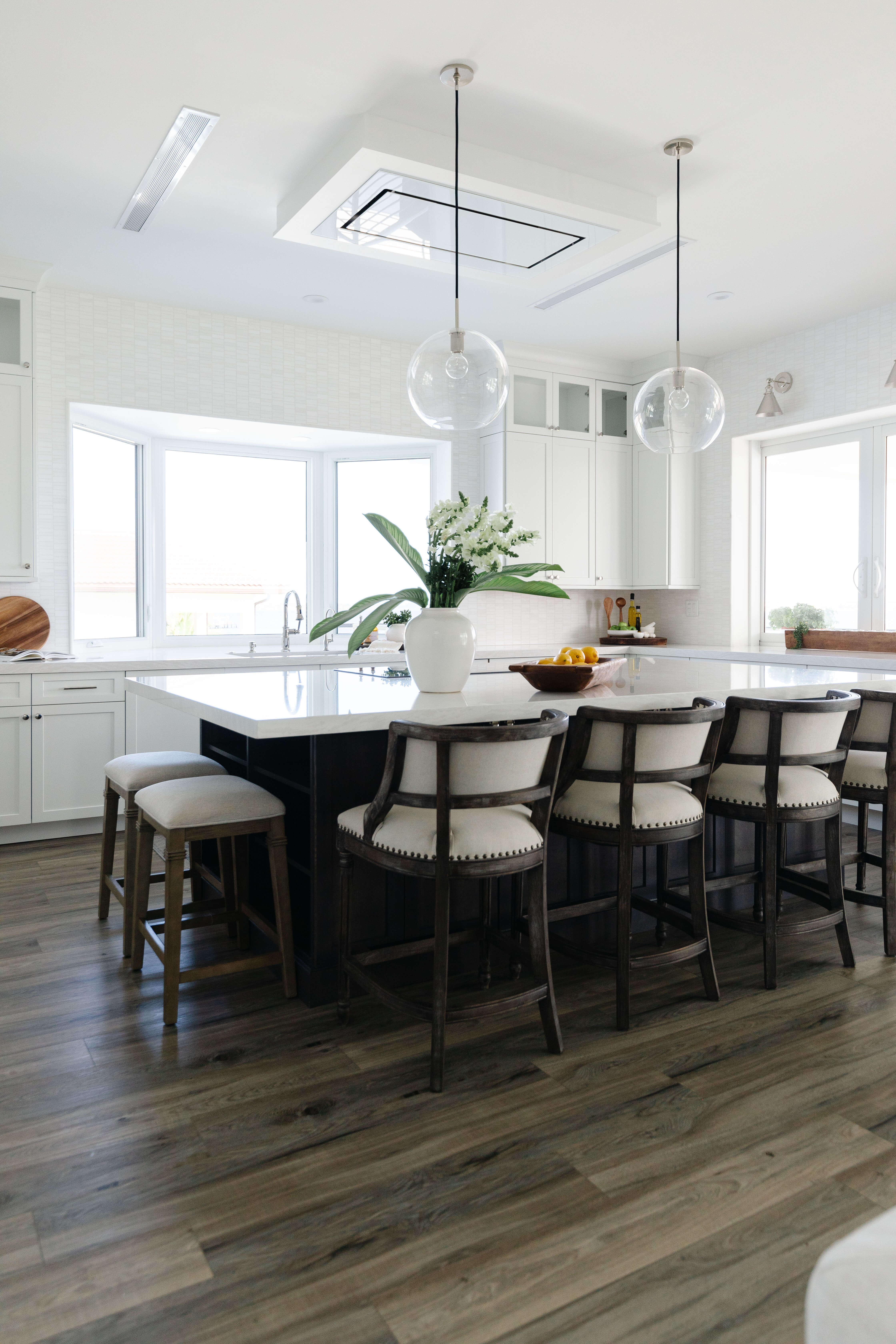 A black and white kitchen design with a beautiful kitchen island the also works as a casual dining room table.