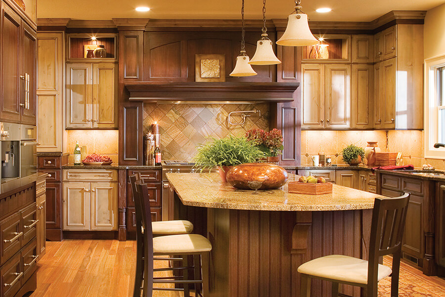 A rustic, traditional kitchen with a mixture of cabinet stain colors.