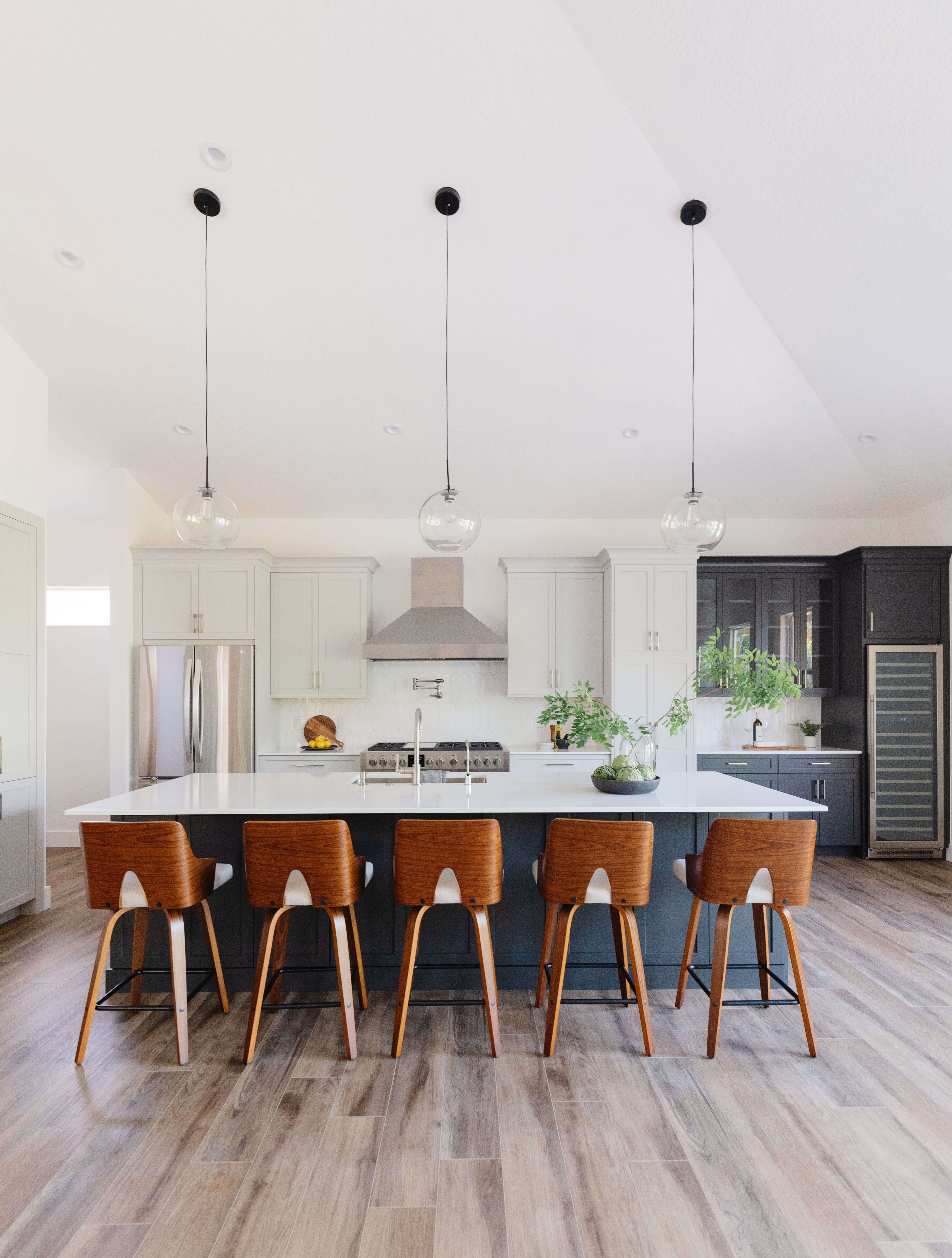 A black and white Mid-Century Modern kitchen with a large kitchen island for 5 and tall vaulted ceilings.