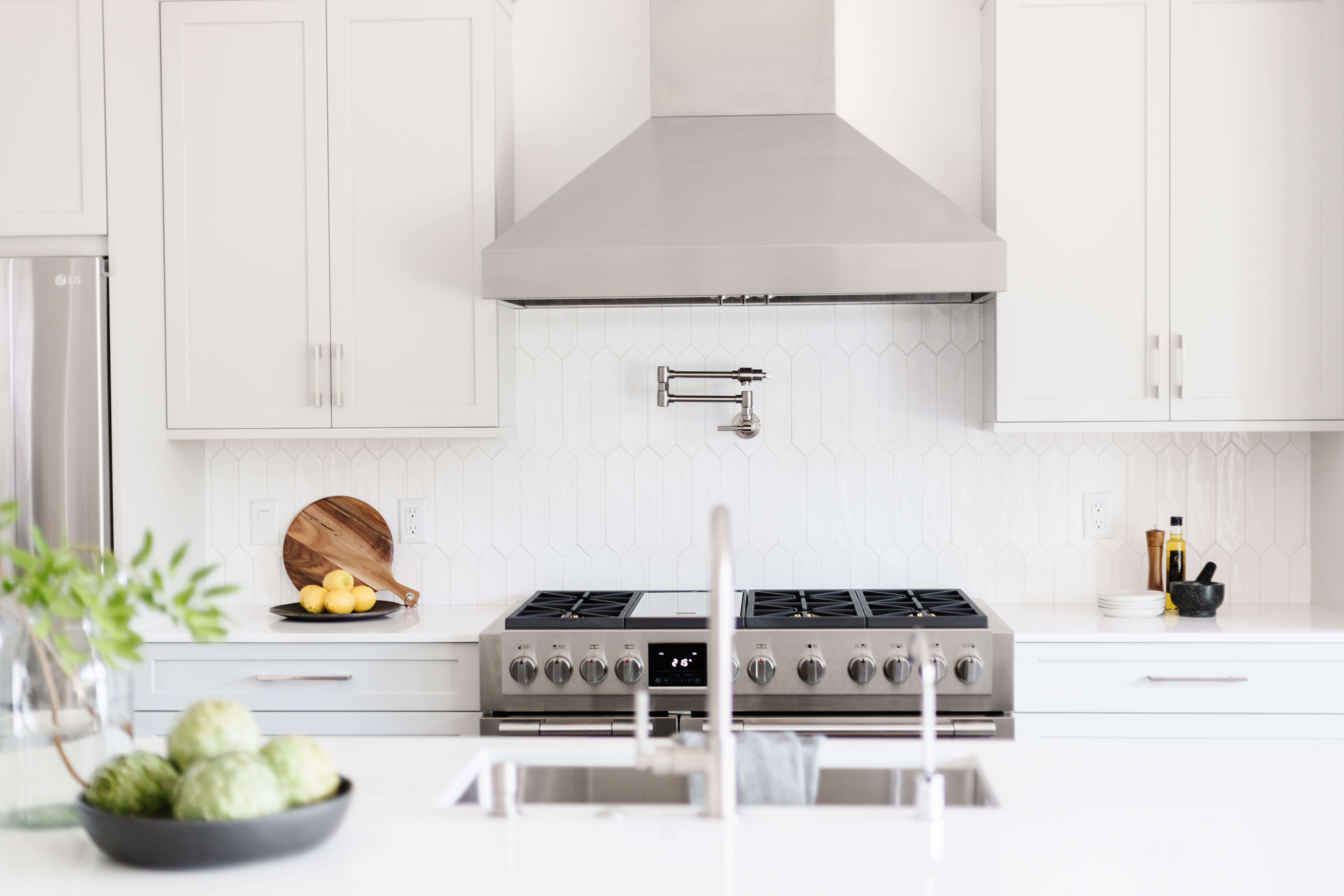 A dreamy Mid-Century modern kitchen remodeled with white painted cabinets ans stainless steel applinaces.