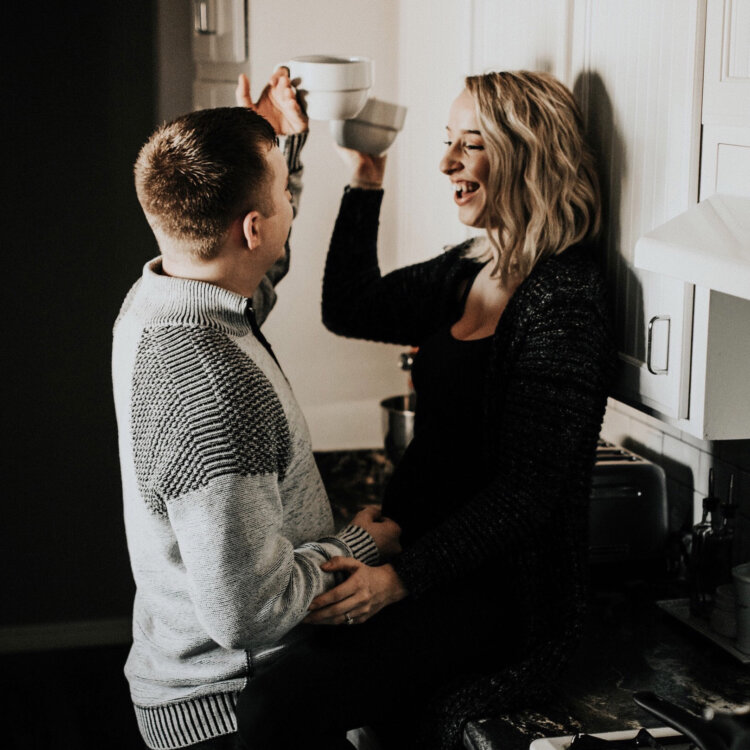 A husband and wife celebrate in their new kitchen as they enjoy the new kitchen layout and cabinets that are designed to fit their lifestyle and storage needs.