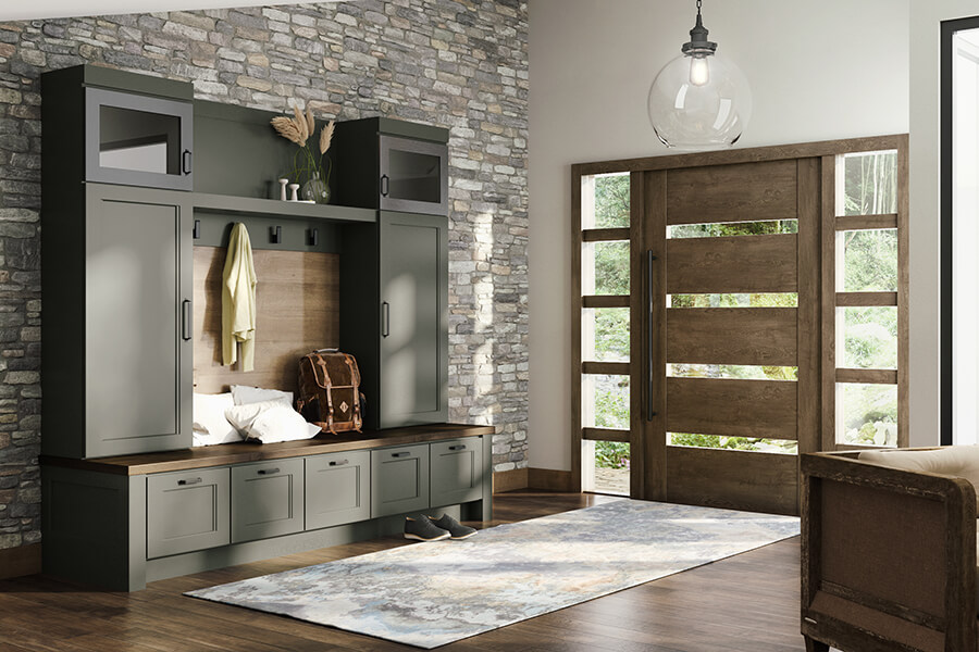 An olive green painted mudroom locker and boot bench built-in to the main entryway of the home.
