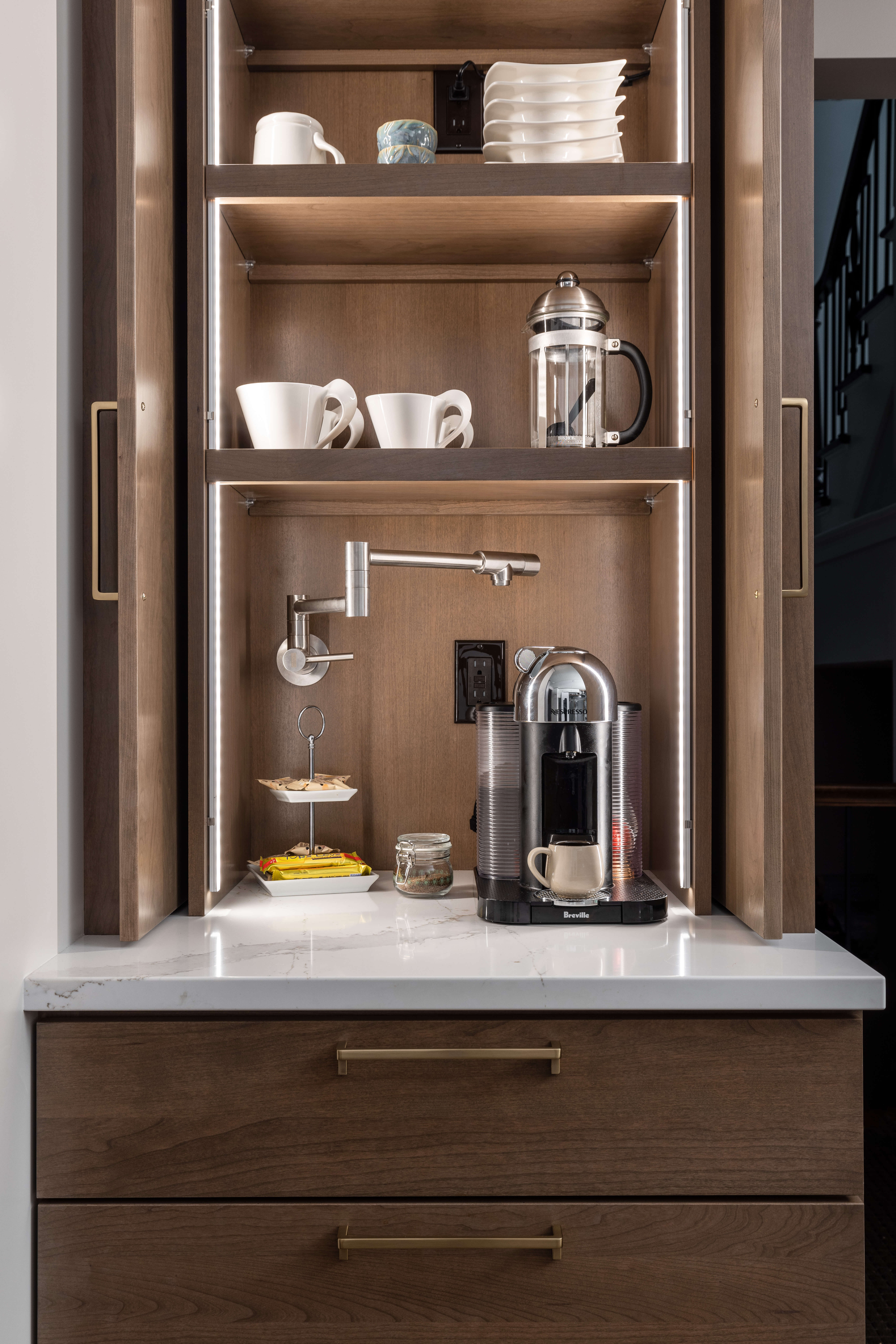 A working pantry and larder cabinet with a pot-filler for the coffee maker to create an easy-to-access coffee station that can be hidden away.