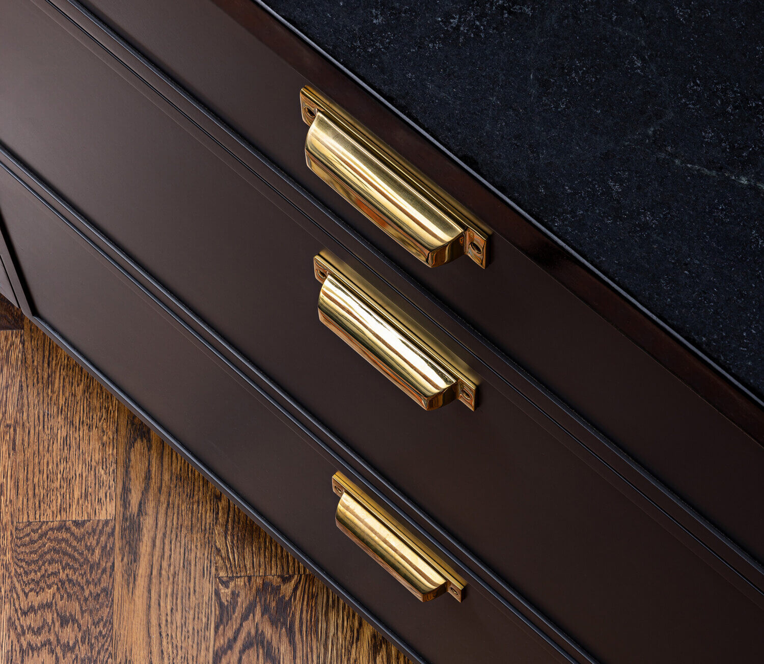 A close up of charcoal black painted cabinets with a modern, skinny shaker door style from Dura Supreme Cabinetry.