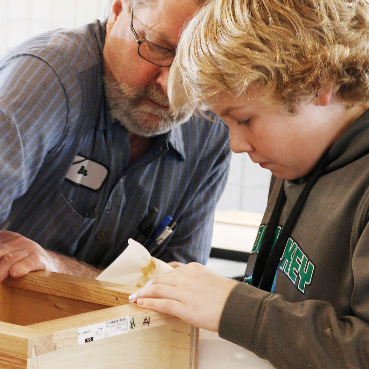 A student and his father building a cabinet together.