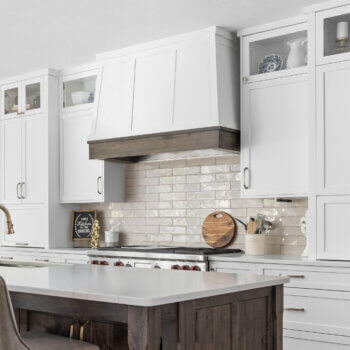 A modern wood hood with transitional styled panels and two toned finishes.
