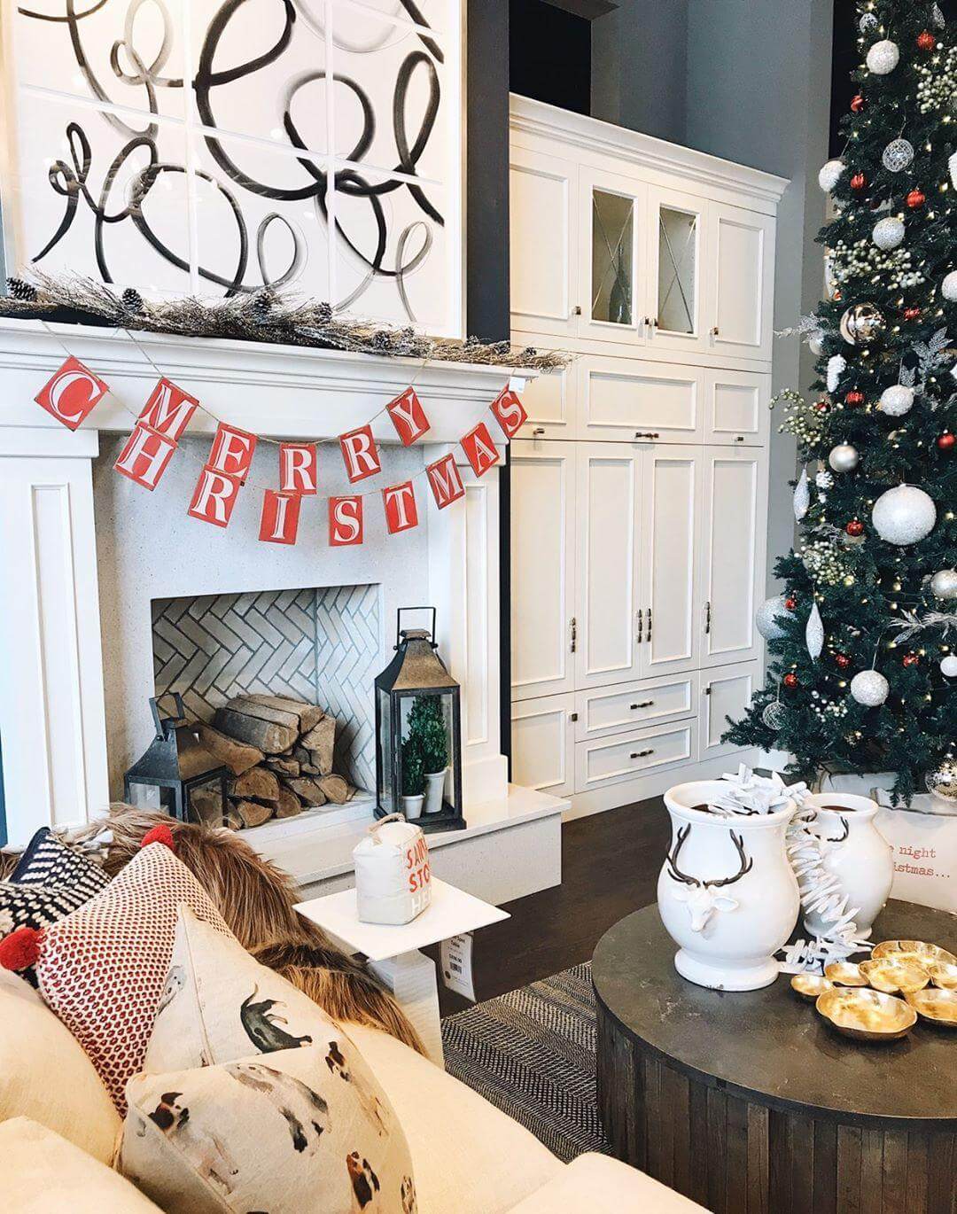 An entertainment center wall with built-in cabinets and a fireplace mantel decorated with Christmas decor.