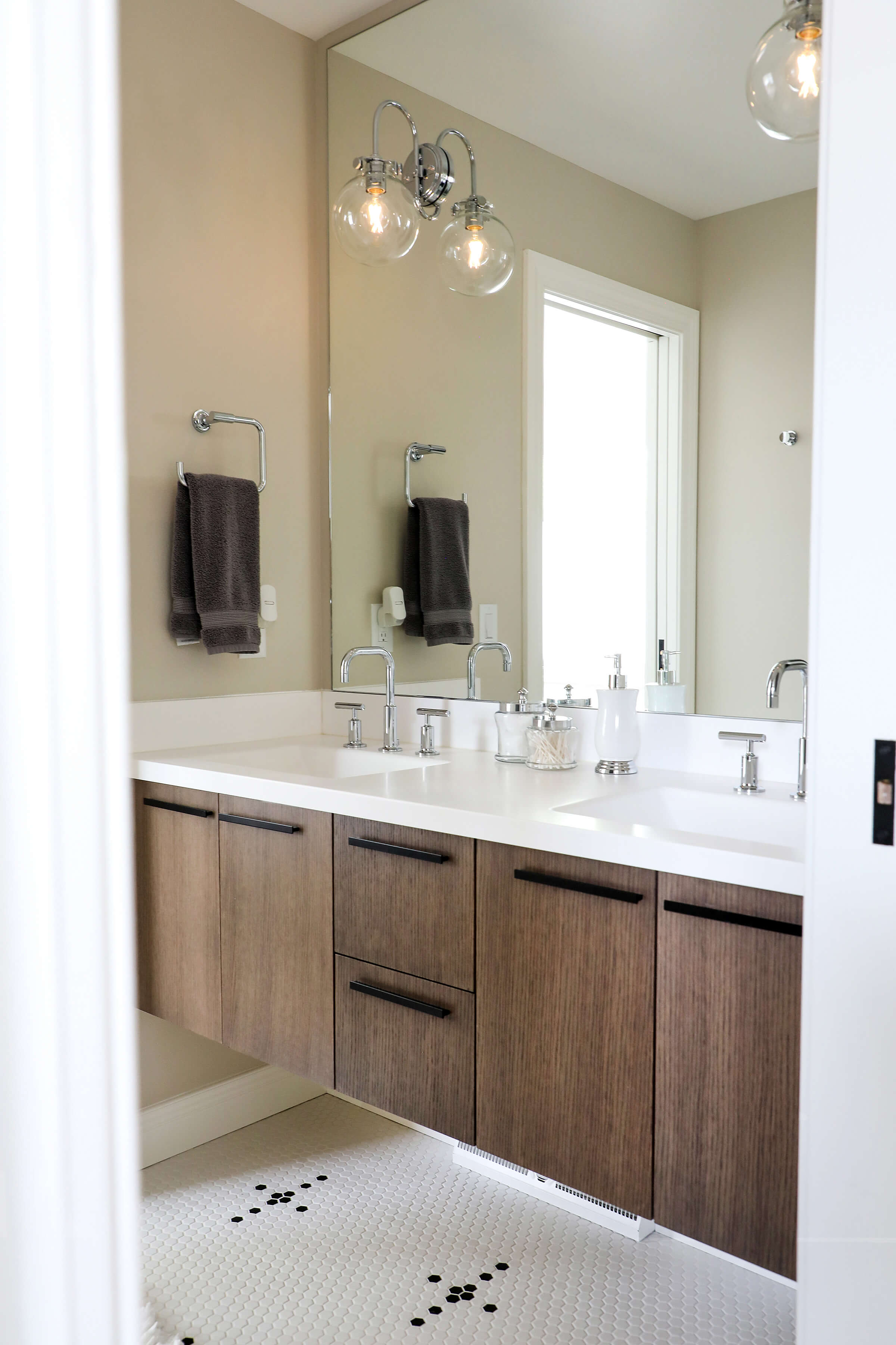 A modern floating vanity with quarter-sawn white oak slab cabinet doors with a sleek vertical grain pattern.
