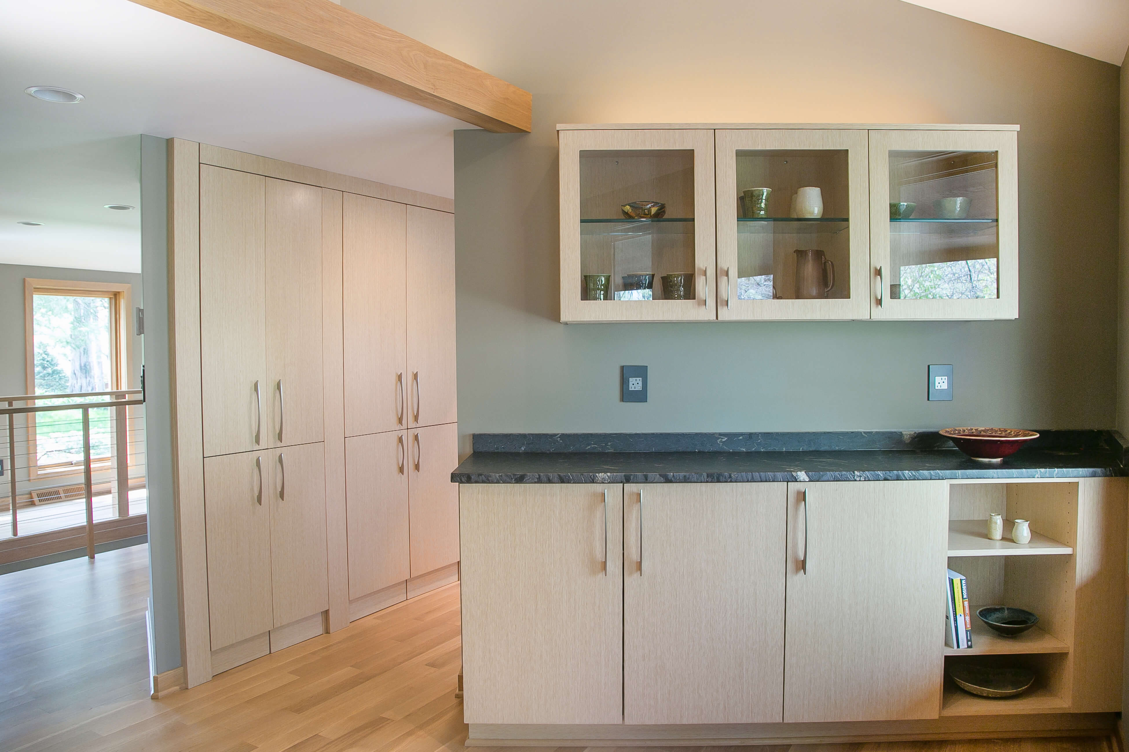 A beautiful contemporary kitchen design with light stained wood cabinets featuring a minimalistic slab door style.