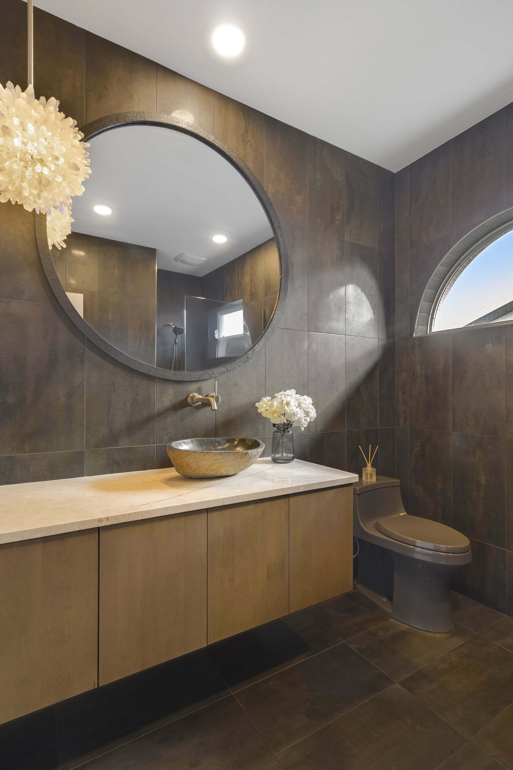 A modern bathroom design with a contemporary styled floating vanity with a sleek slab door style. with a stained finish.