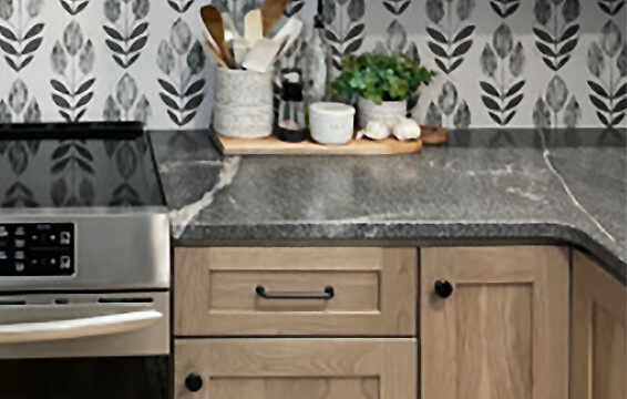 A beautiful kitchen with light stained wood cabinets from Dura Supreme Cabinetry.