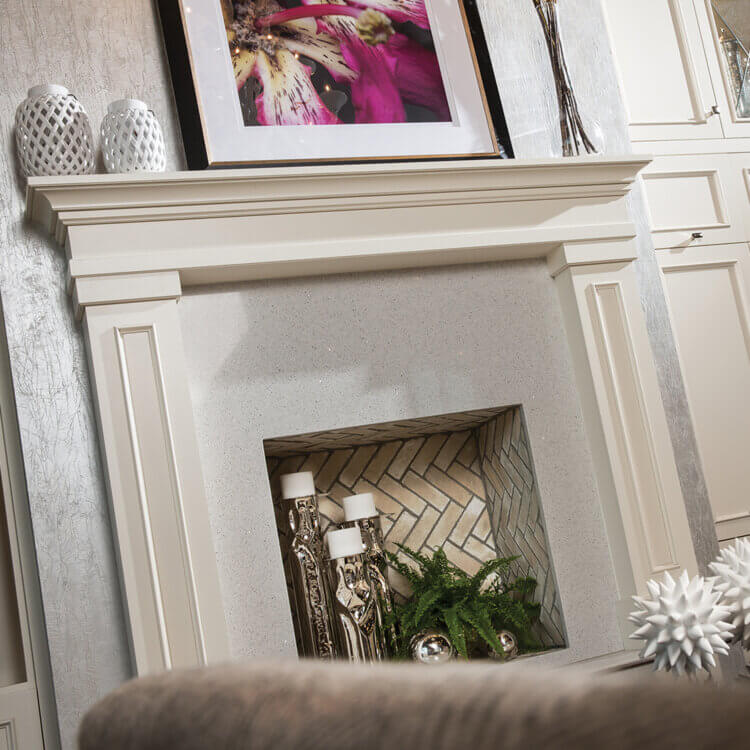 A close up of a white painted fireplace mantel from Dura Supreme Cabinetry.