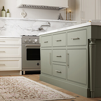 A remodeled kitchen with natural white and sage green painted cabinets with inset cabinets from Dura Supreme.