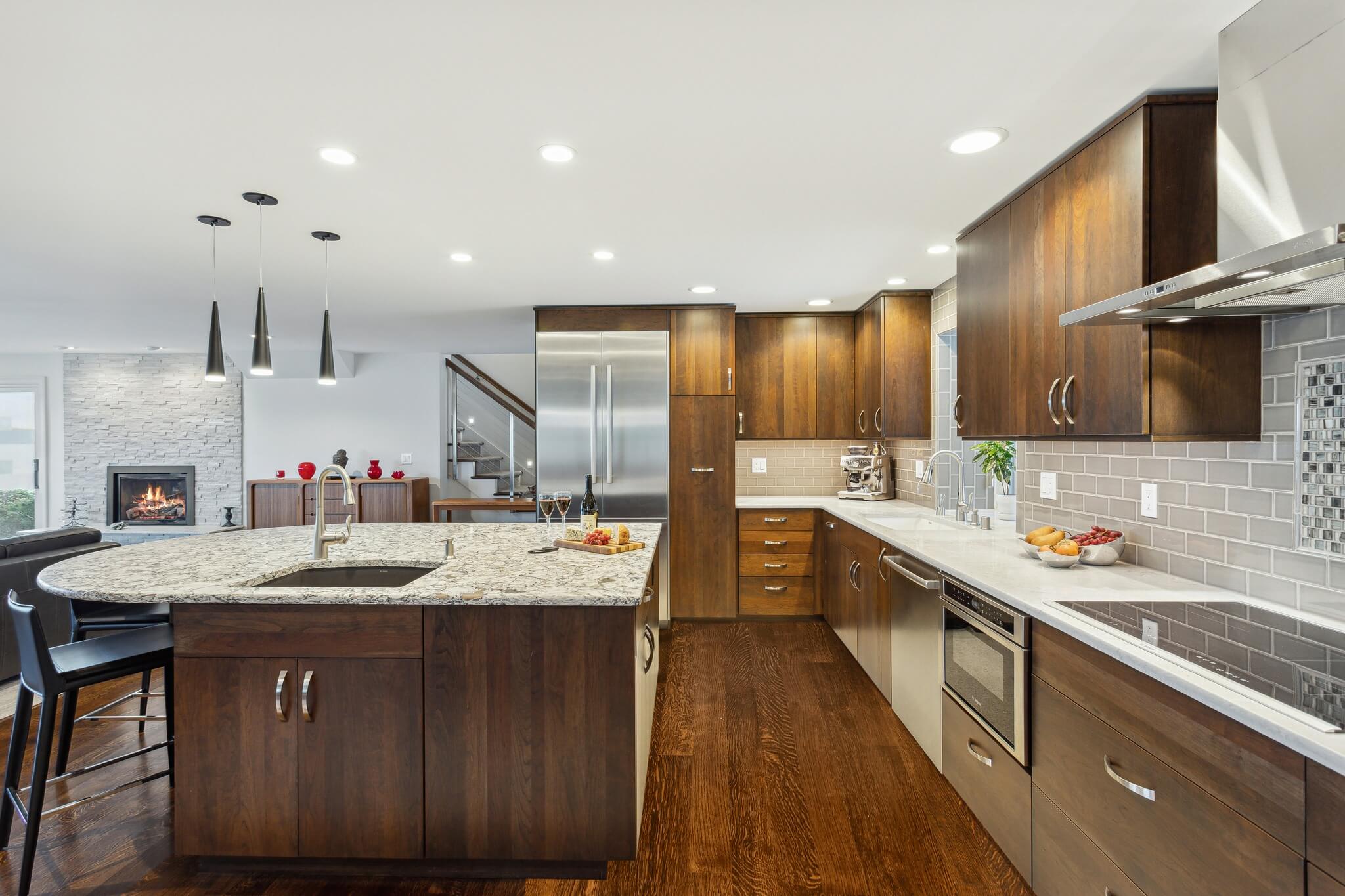 A modern kitchen design with warm stained cabinets with a slab door style.