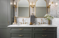 A furniture styled bathroom vanity with almost black, dark green cabinets from Dura Supreme.