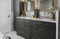 A trendy bathroom remodel with a popular dark green painted finish for the bathroom vanity and tall linen cabinet.
