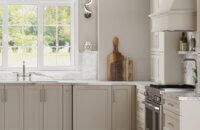 A luxurious off-white painted kitchen with a dramatic flat panel cabinet door.