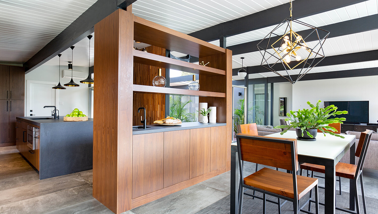 A room divider made with cabinetry in a mid-century modern new home build.