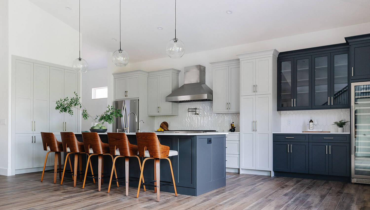 A two-toned mid-century modern kitchen design with uses black and white painted cabinets.
