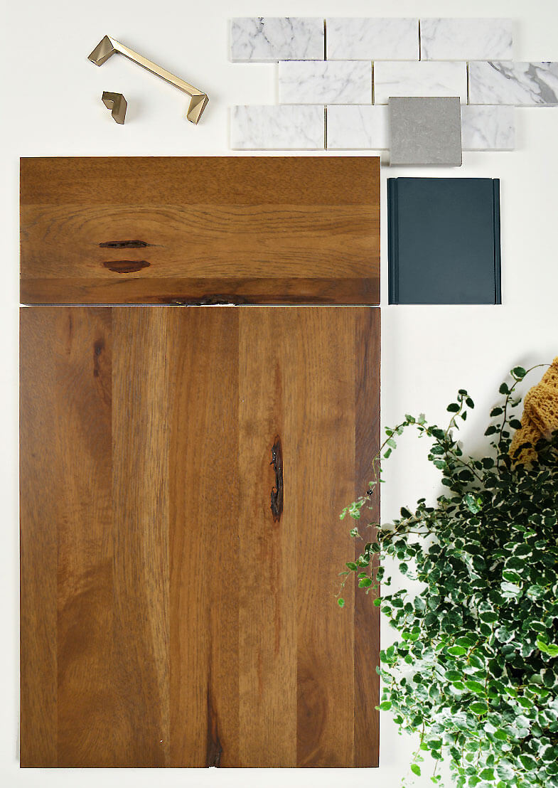 A mid-century modern kitchen design mood board with a rustic wood slab door, blue paint, white tiles, an brass hardware.