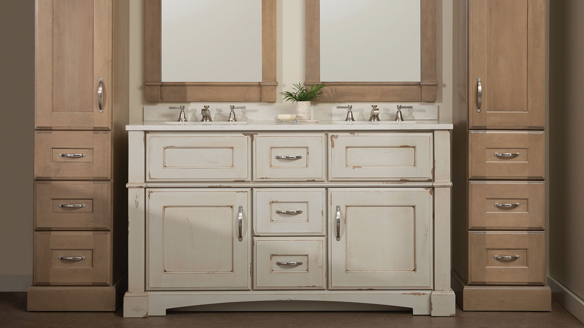 An all beige bathroom using a mix of a distressed beige painted finish on the bathroom vanity and a coordinating true-brown stained maple linen cabinets.