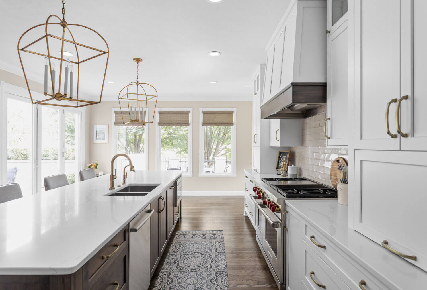 A two-tone kitchen design with white and dark stained knotty alder cabinets. A modern wood hood is painted white with a knotty alder stained freeze that matches the kitchen island.