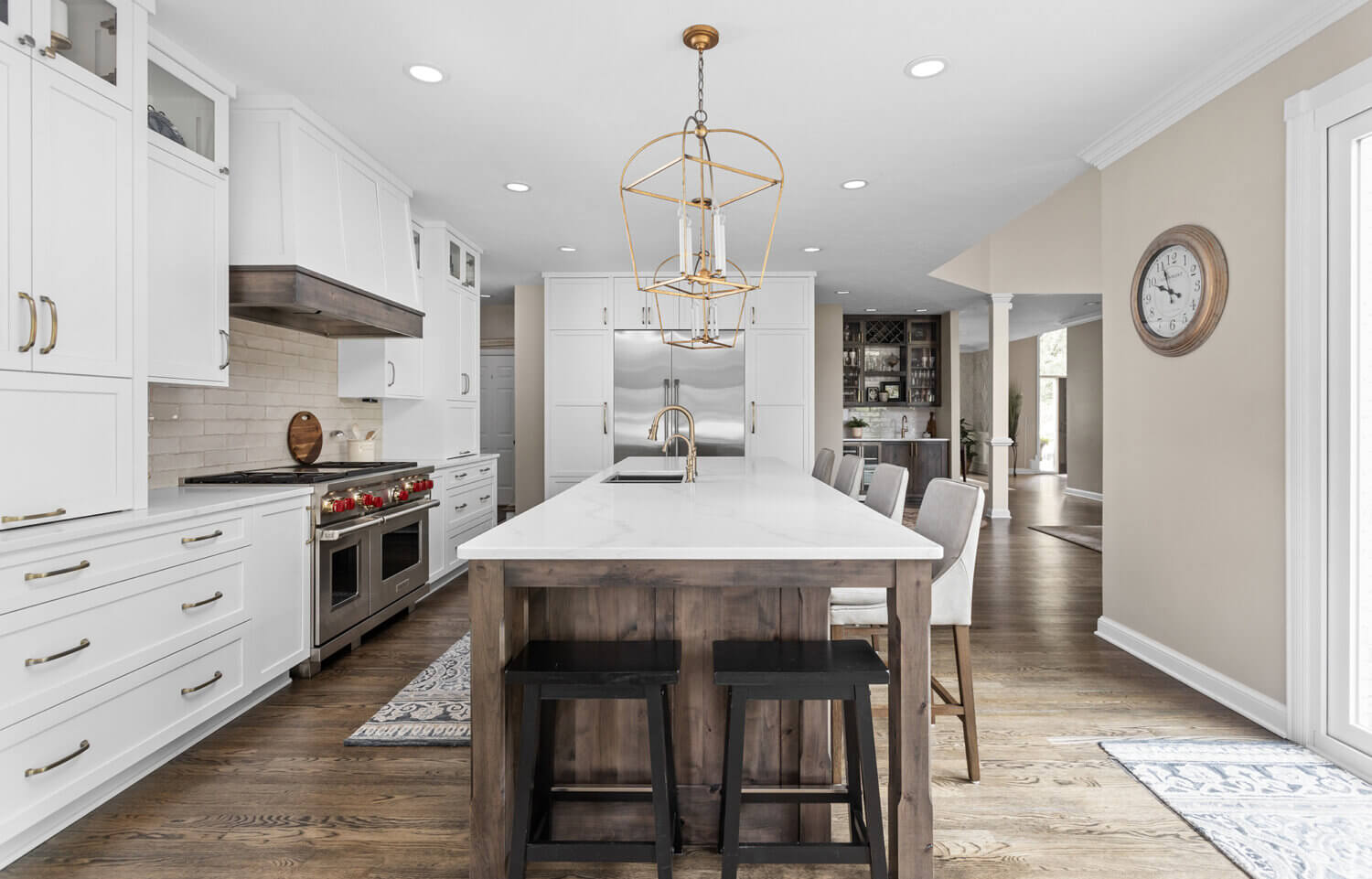 This kitchen has seating for two at the end of the kitchen island. The kitchen remodel features a mix of white and rustic knotty alder cabinets from Dura Supreme Cabinetry.