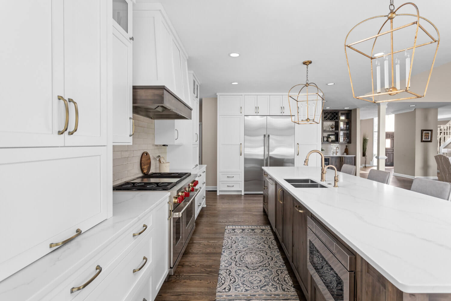 A beautiful kitchen remodel with white cabinets and rustic wood cabinets featuring a kitchen island and a two-toned wood hood.
