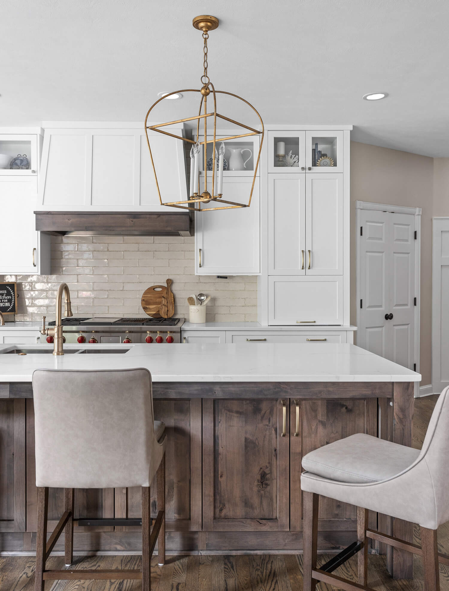 A beautiful transitional kitchen with shaker cabinet doors shown in a white paint and brown stained knotty alder wood.