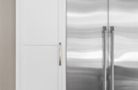 White shaker cabinetry around a stainless steel fridge.