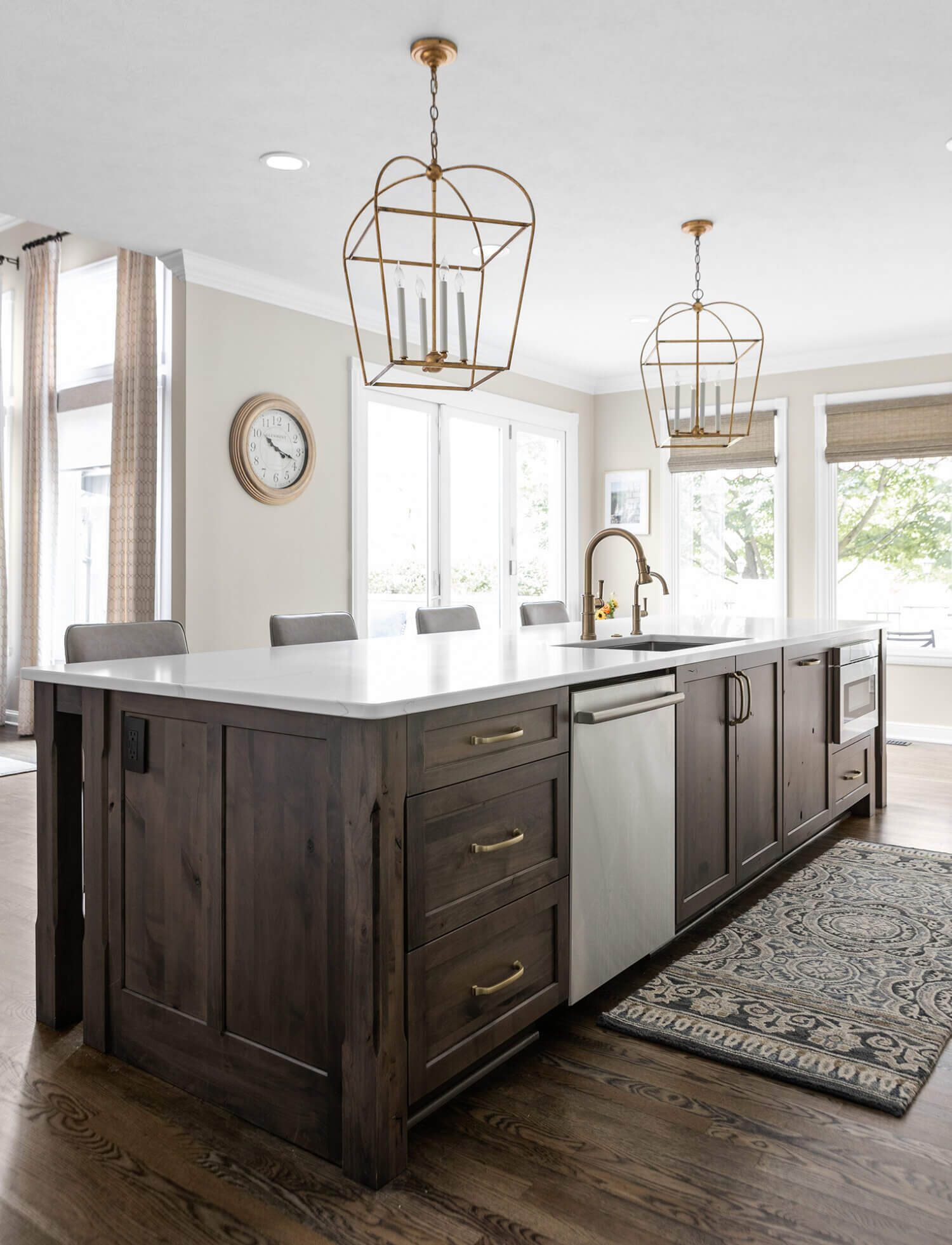 A rustic knotty alder kitchen island with seating for six and two large pendant lights.