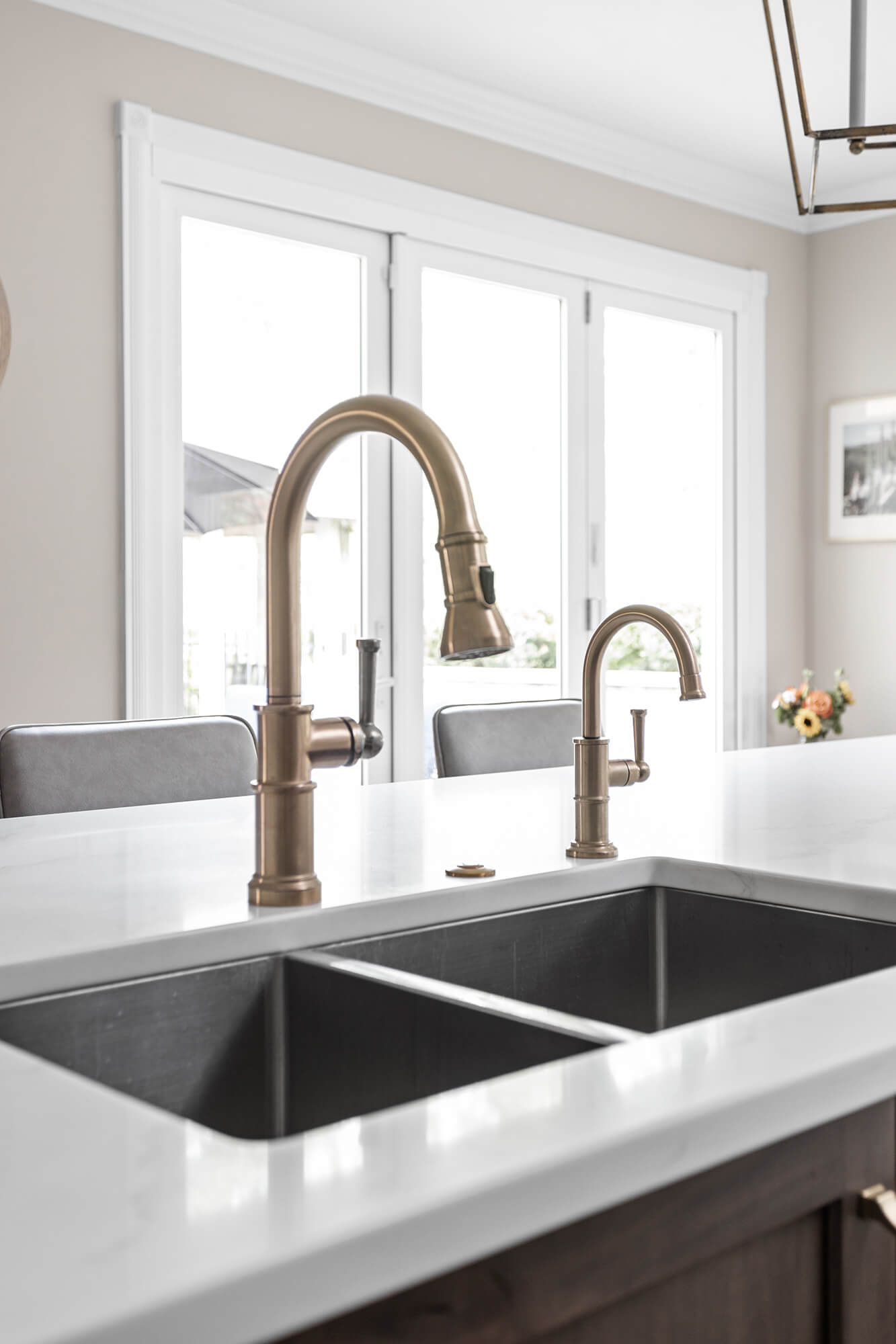 The double sink at the kitchen island has a brushed brass finish on the faucet.