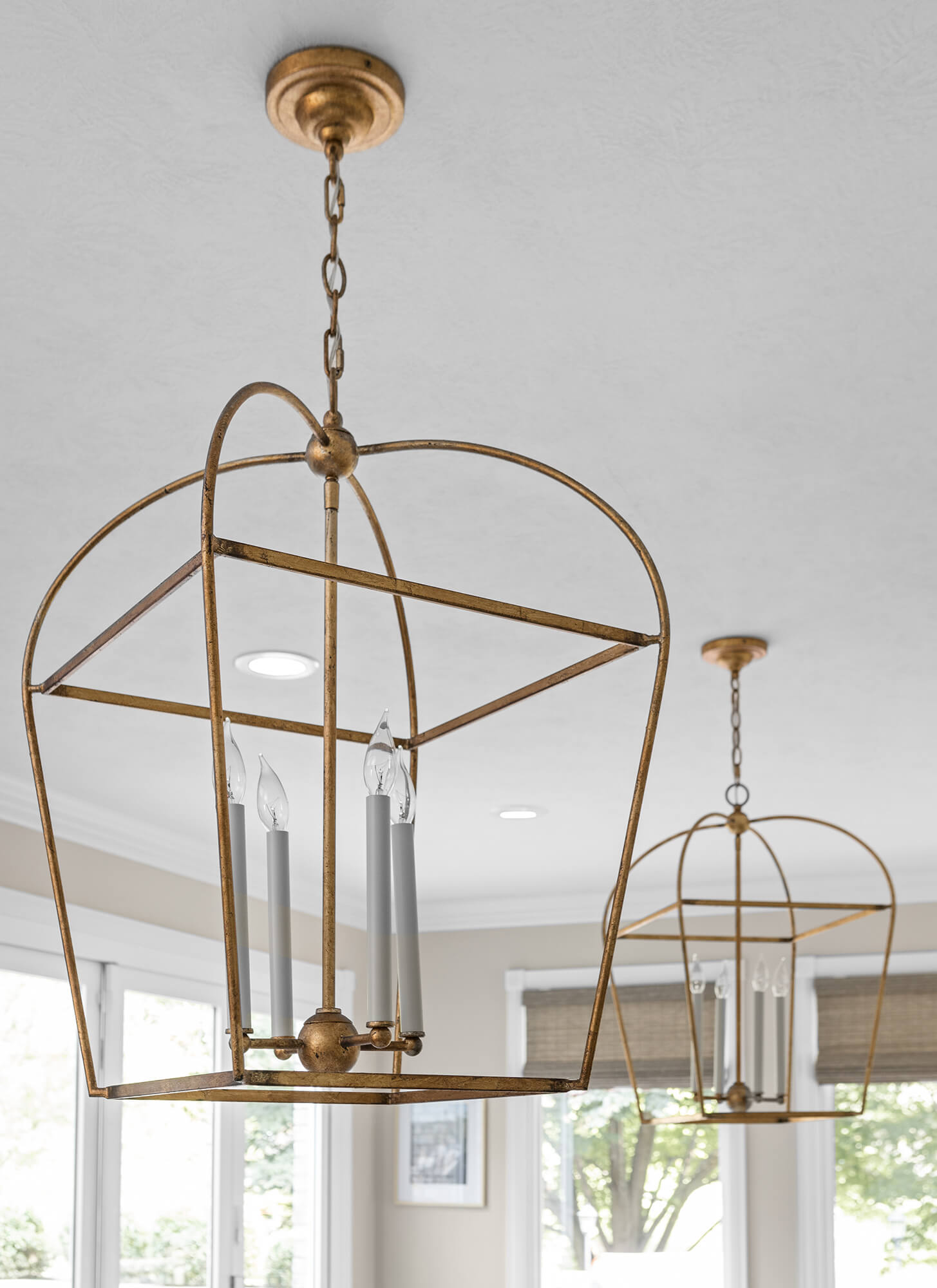 Two brushed brass lantern-style pendant lights for above a kitchen island.
