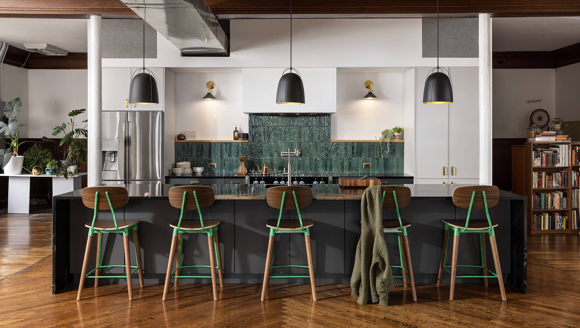 An urban remodel with charcoal gray cabinets with sleek modern shaker cabinets doors with a frameless construction. Featuring an Emerald Green backsplash and true-brown stained wood accents.