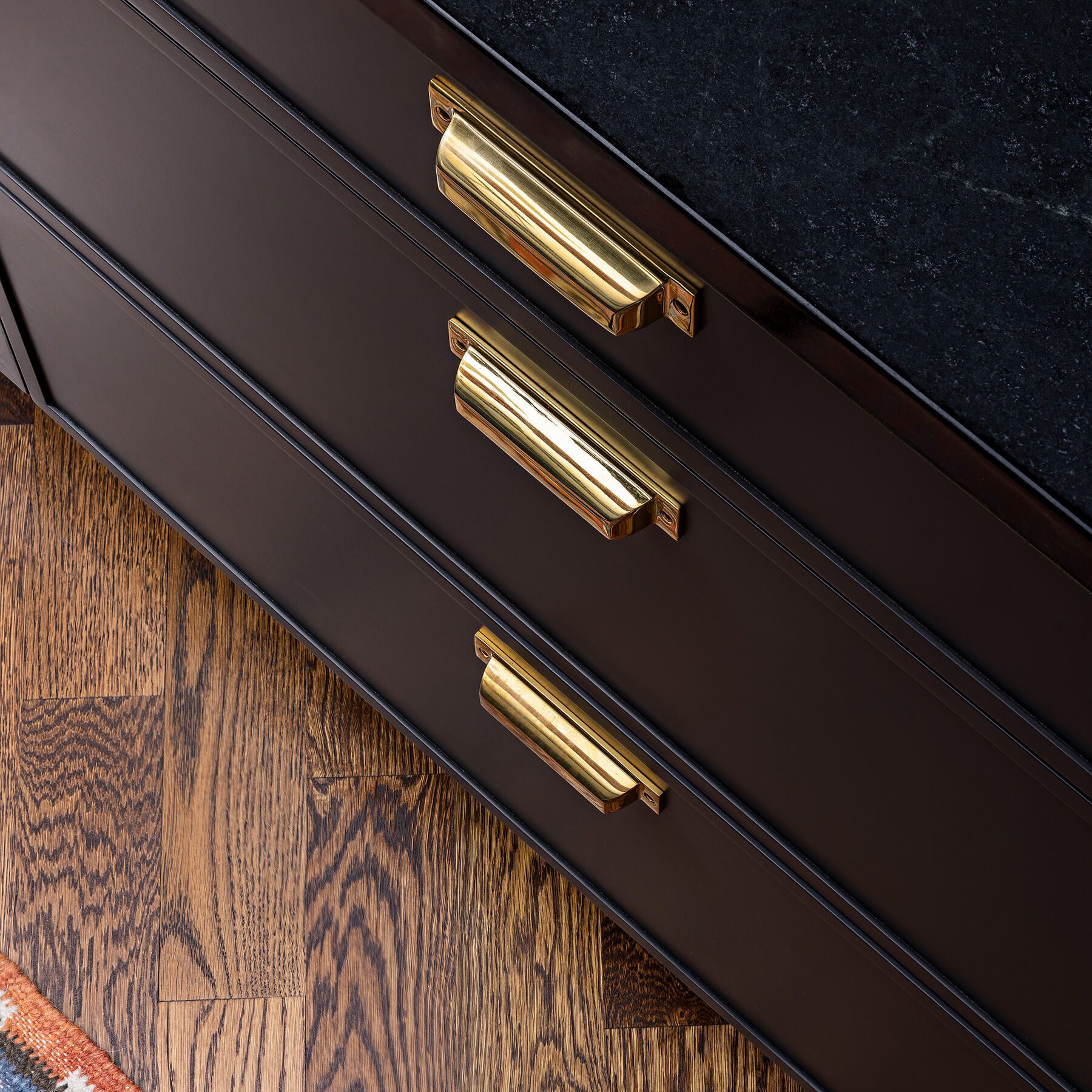 A close up of charcoal black painted cabinets with a modern, skinny shaker door style from Dura Supreme Cabinetry.