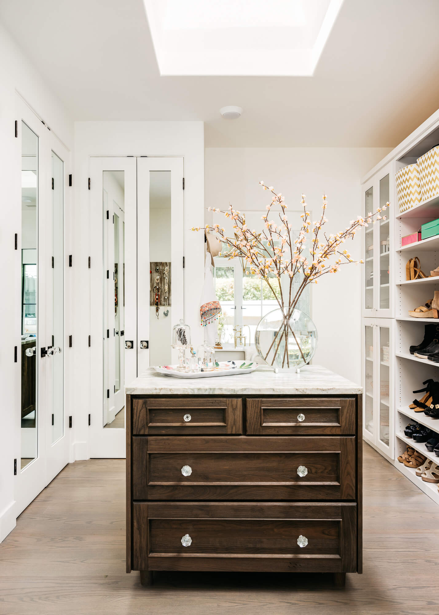 A beautiful walk-in closet with custom cabinetry and a pretty closet island.