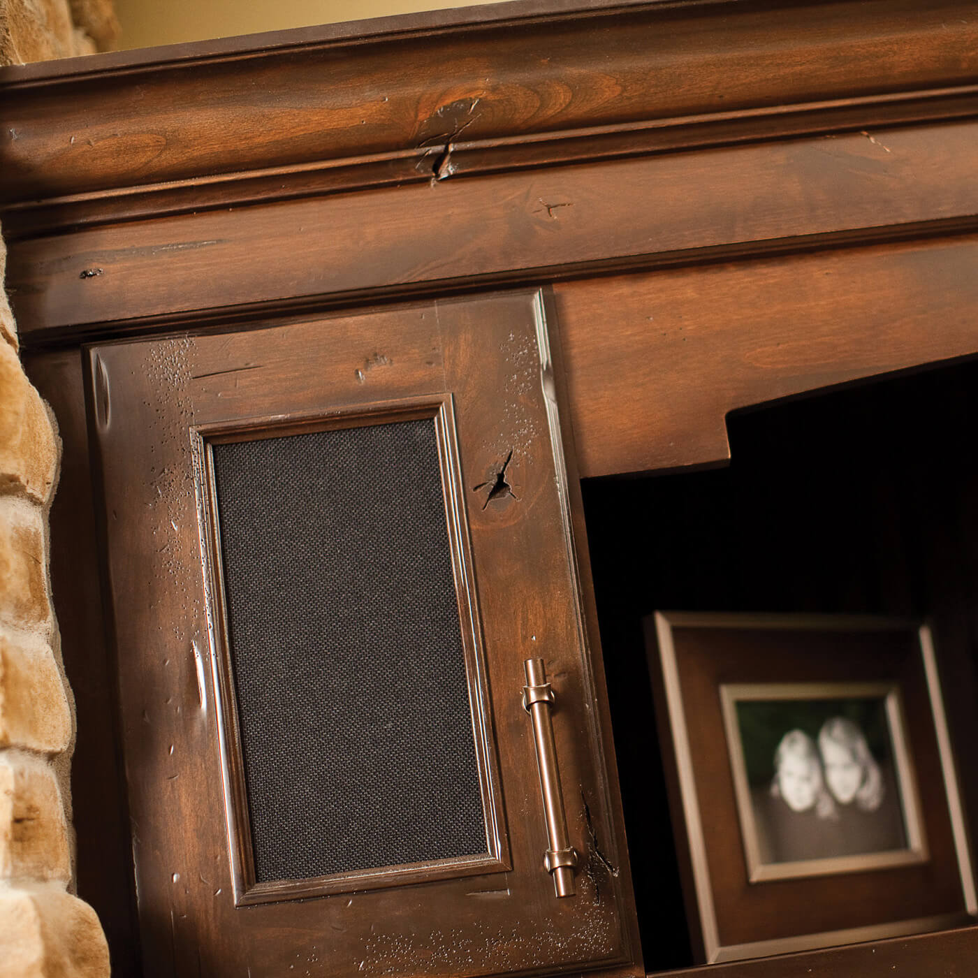 A speaker cloth insert can make a cabinet a breathable space for storing electronics and hiding speakers in an entertainment center from Dura Supreme Cabinetry.