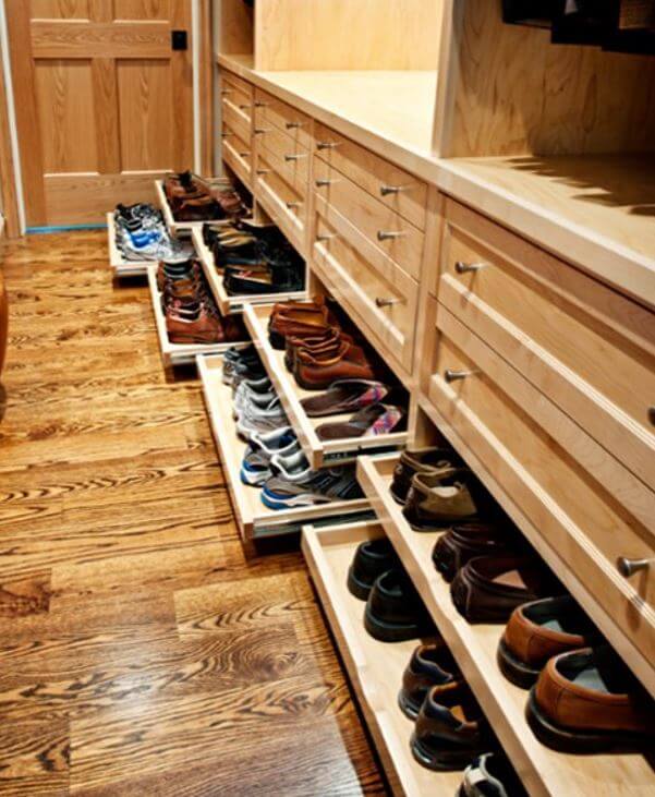Roll-out shelves for shoe storage in a walk-in closet.