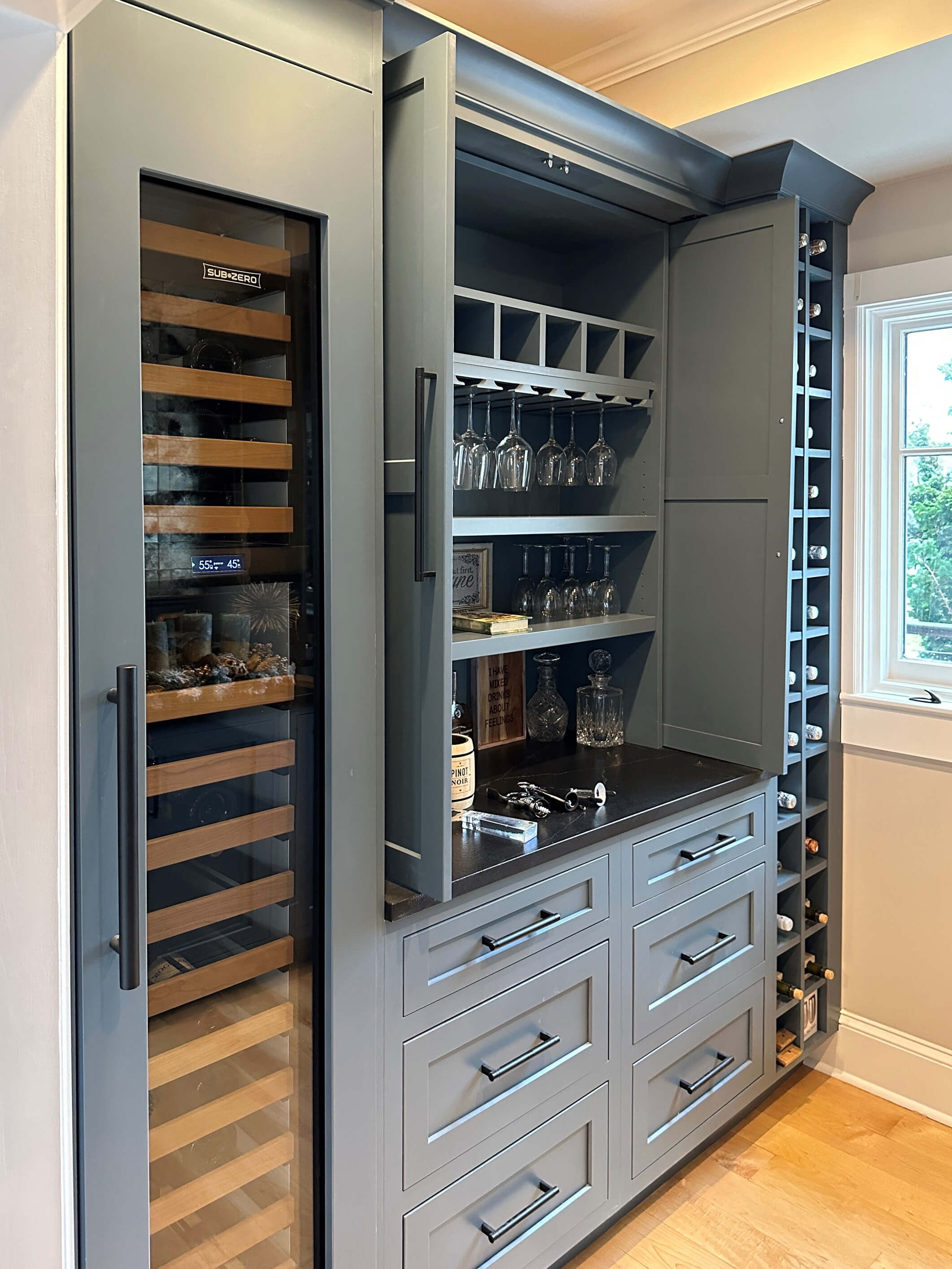 A full wall home bar and larder cabinet for a hidden beverage making work station.