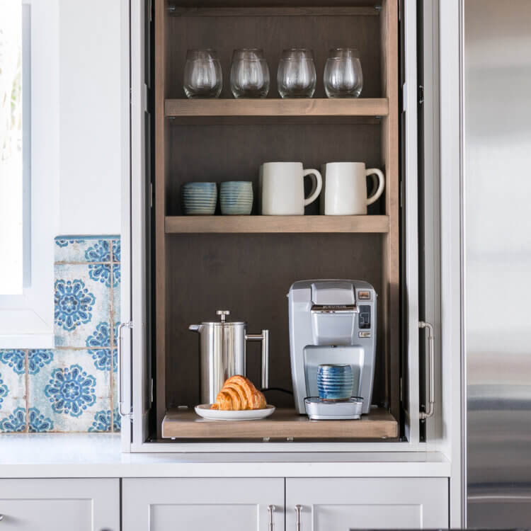 A close up of a larder cabinet created to be a hidden coffee station.