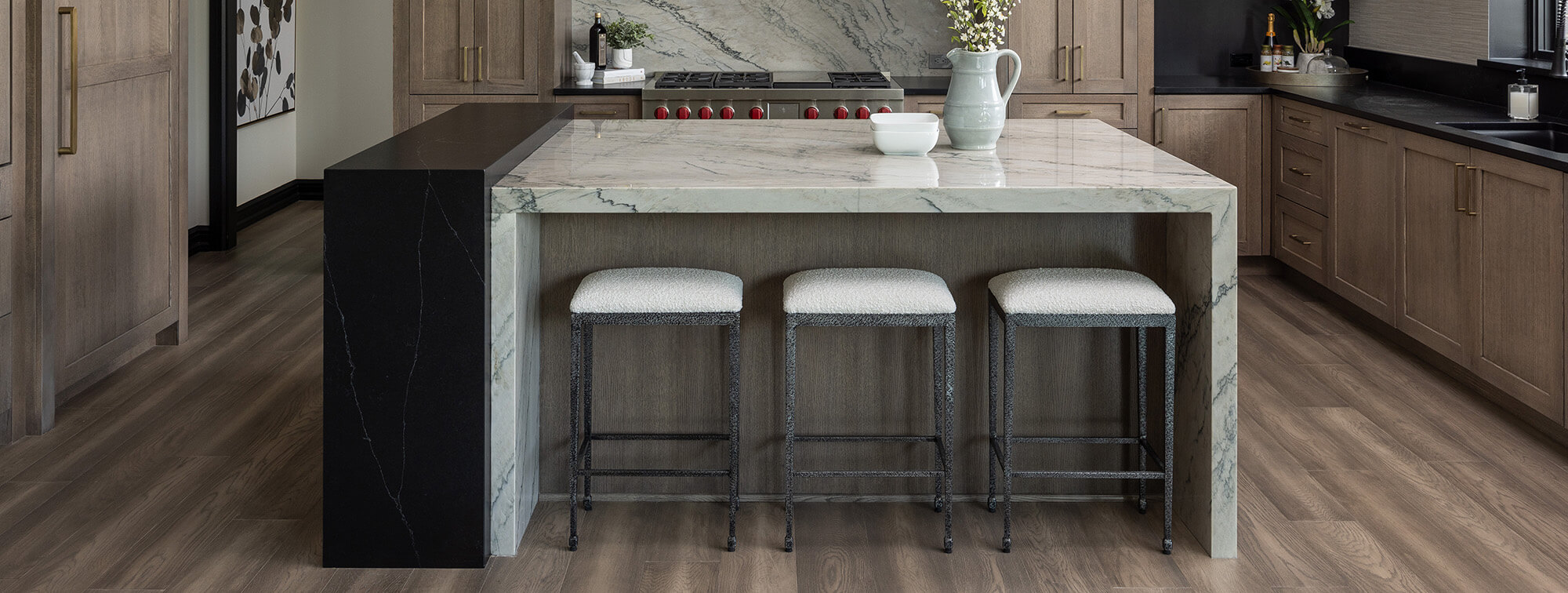 A stunning kitchen island with 4 waterfall countertops and seating for three.