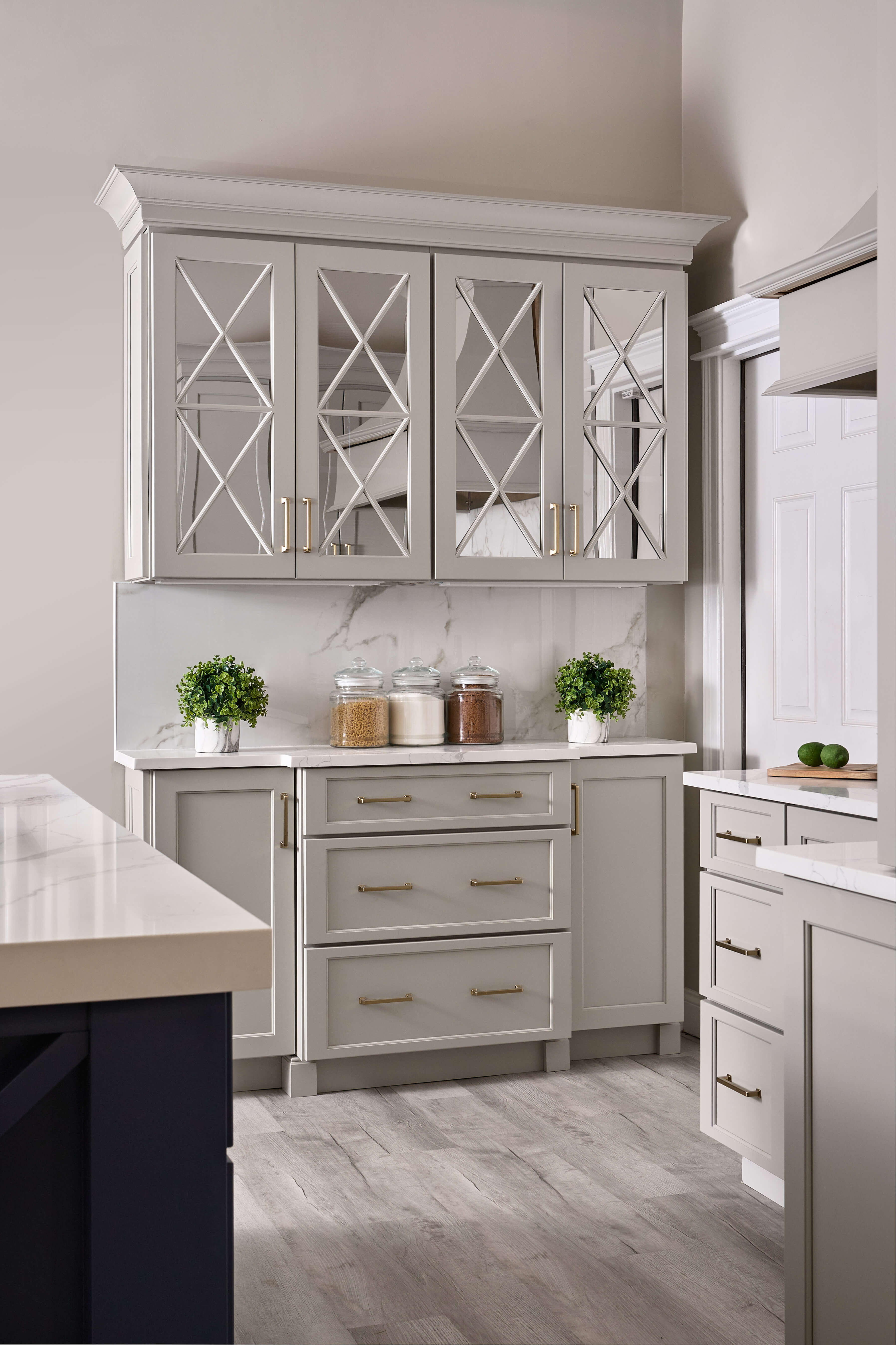 The mullion cabinet doors in this beautiful kitchen use mirror inserts to add drama, and beauty to the space.