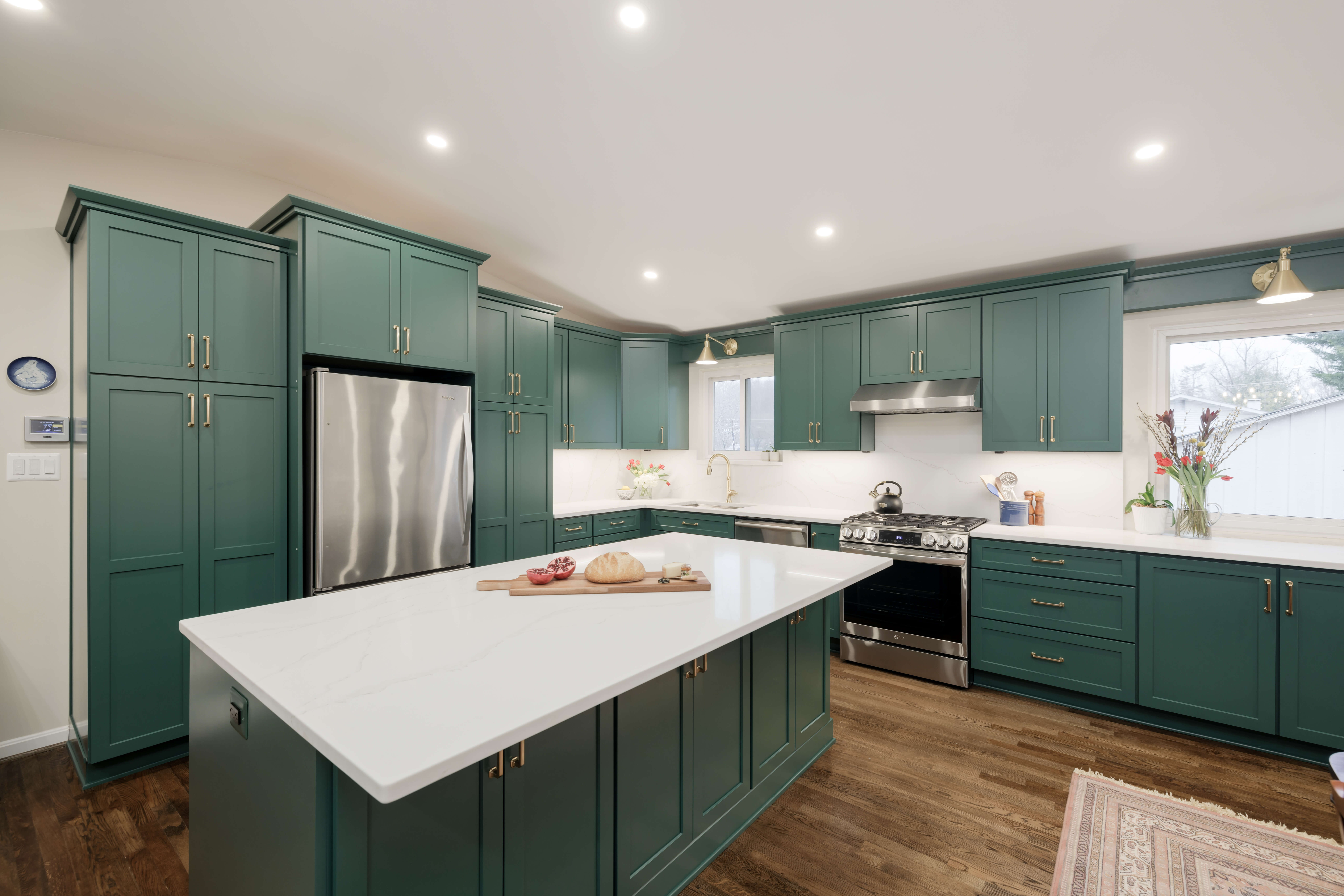 A teal/blue kitchen with a colorful custom painted cabinets with a shaker door styl