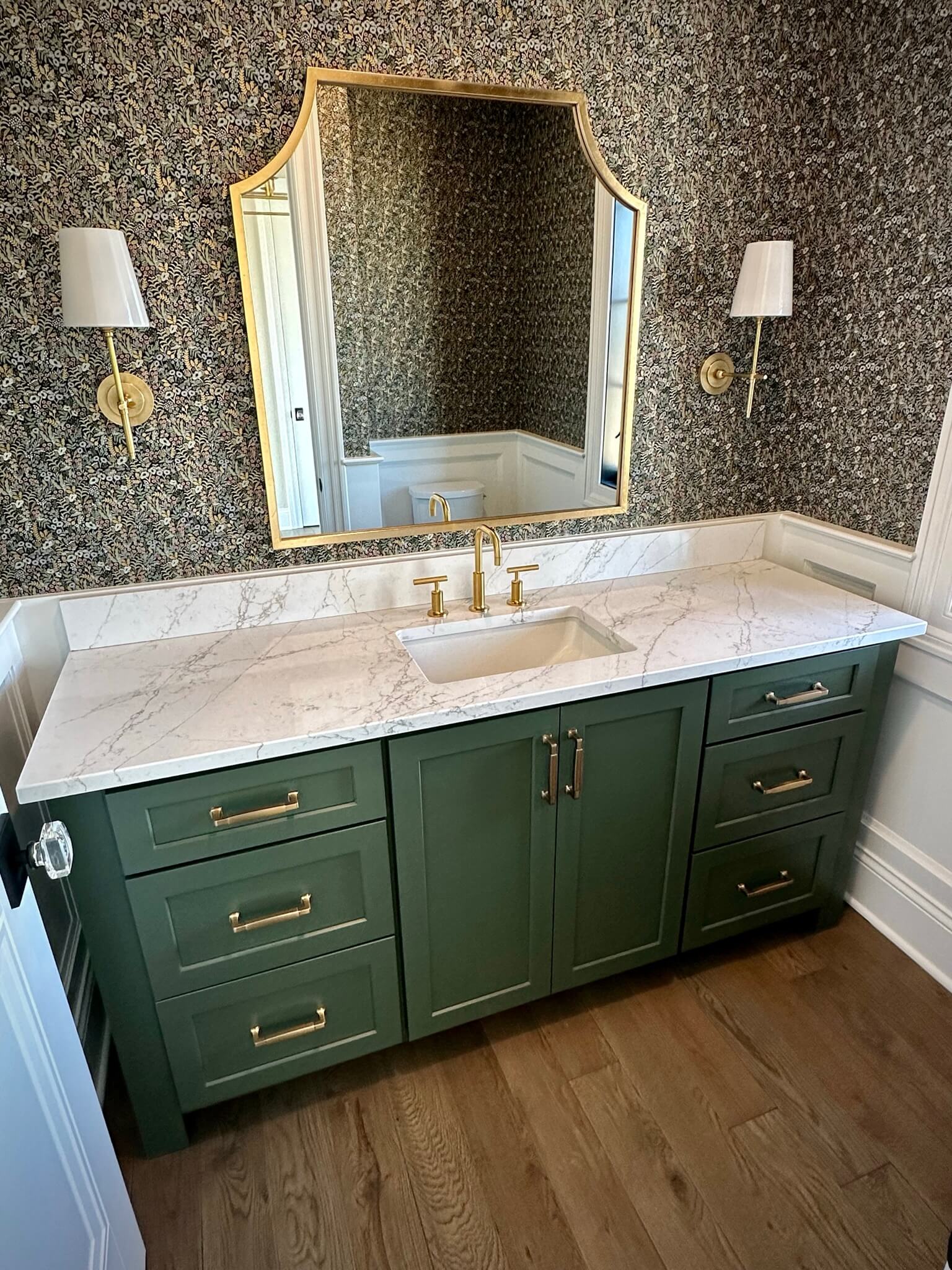 An elegant bathroom with an emerald green vanity crafted by Dura Supreme Cabinetry.