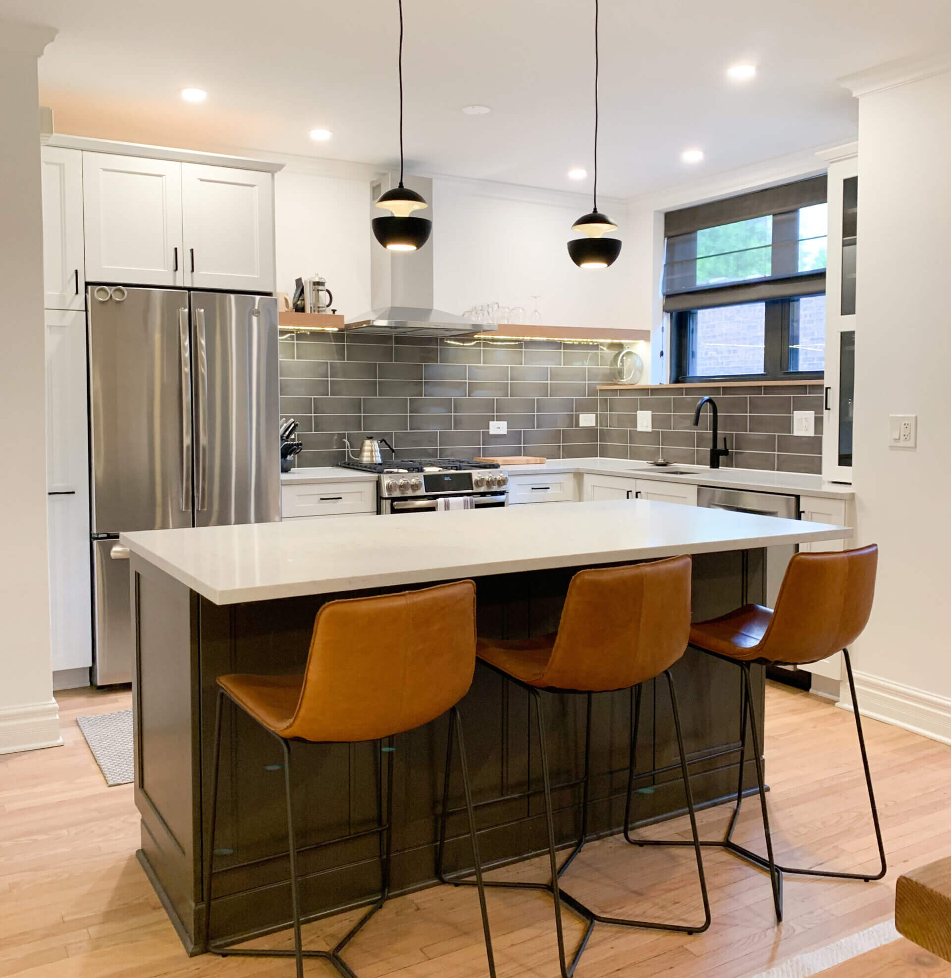 A kitchen remodel with two custom paint colors featuring a white paint for the perimeter and a dark bronze paint for the kitchen island.