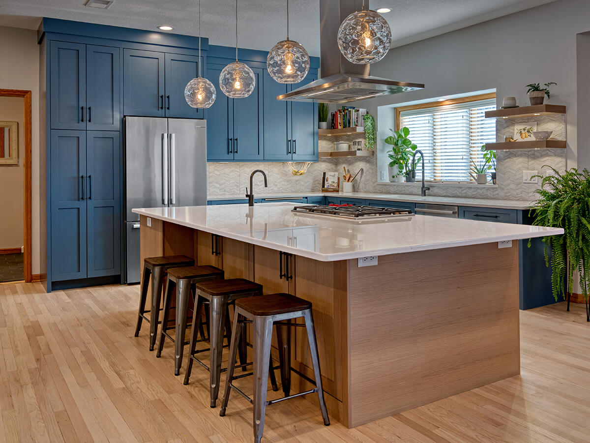 A bold and blue kitchen design that mixes wood cabinets with a bright blue paint color.